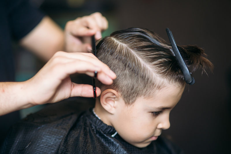 Ett barn som blir klippt hos en barberare.